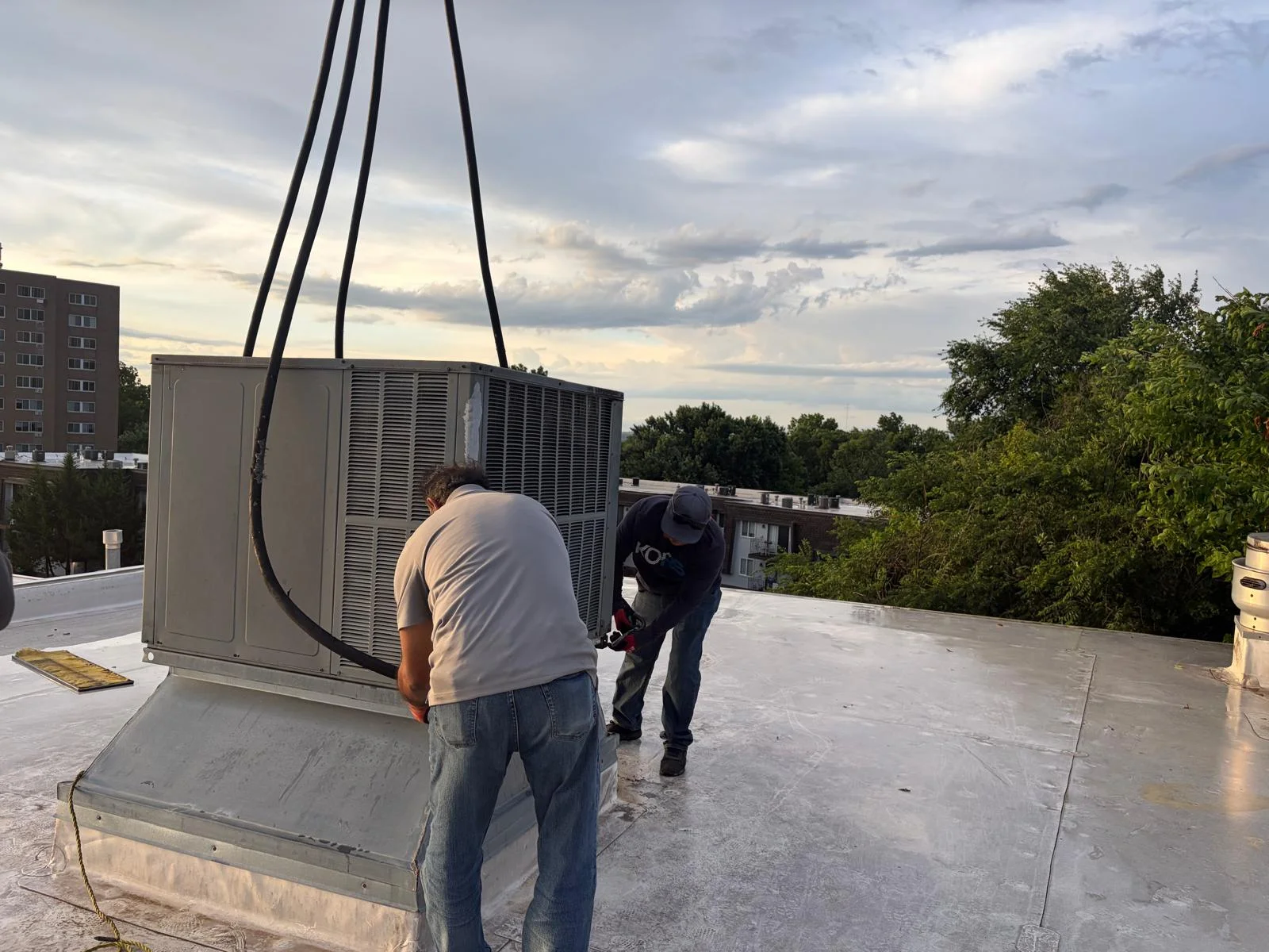 Technicians setting up a rooftop commercial HVAC package unit